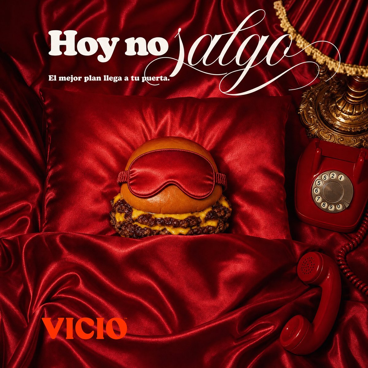 Anuncio de Vicio: una hamburguesa con antifaz, acostada en una cama de satén rojo. «Hoy no salgo».