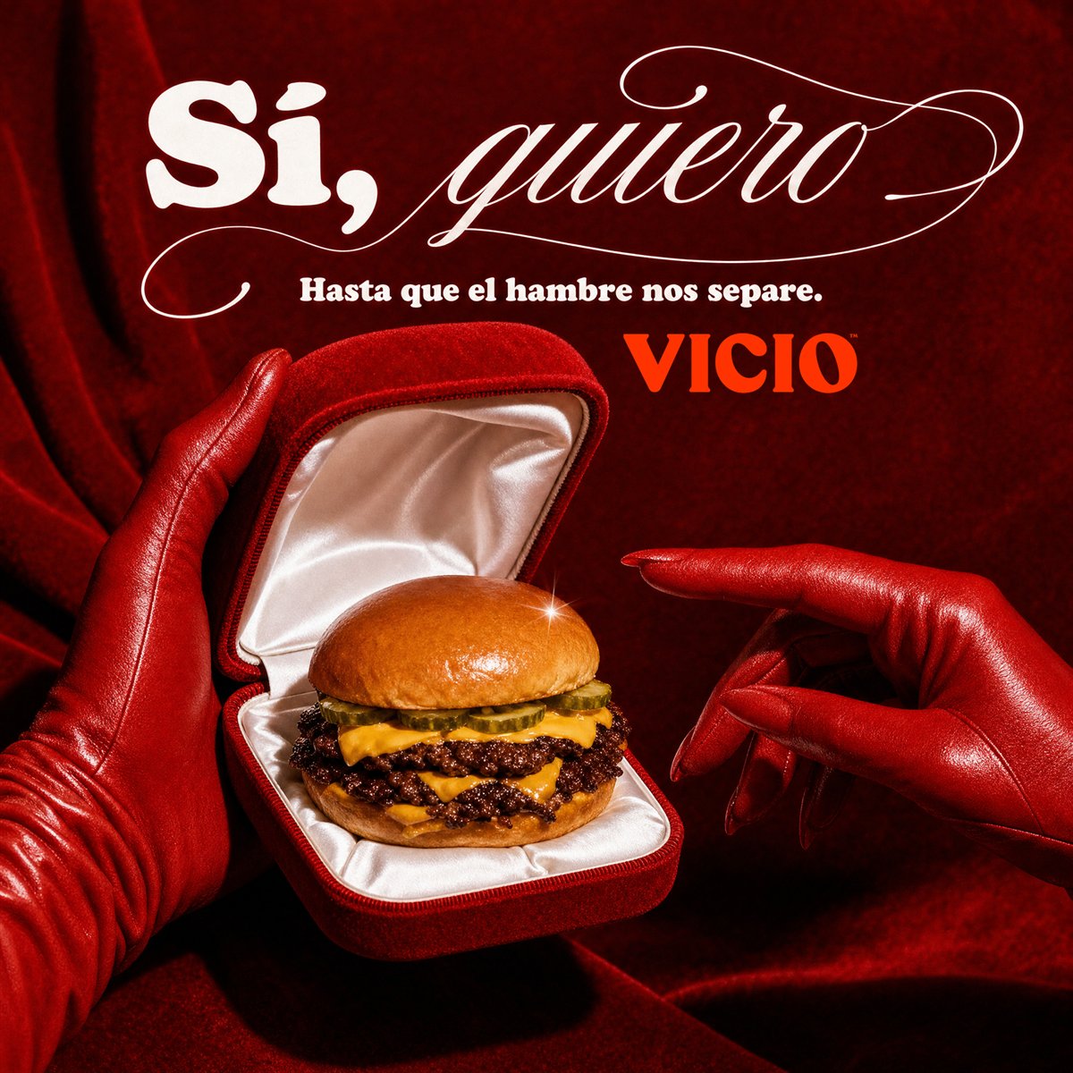 Anuncio de Vicio: una hamburguesa en un estuche de anillo, entre dos manos con guantes rojos. «Sí, quiero».