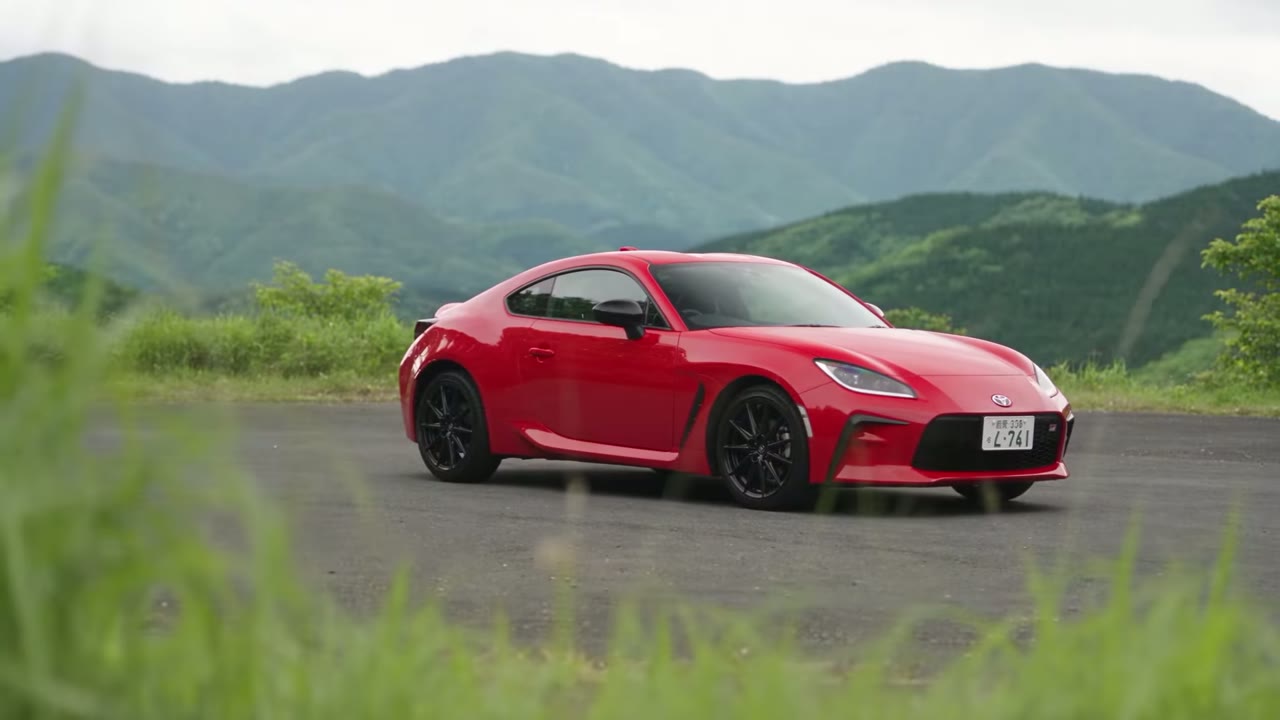 El GR86 rojo en una carretera de montaña, con las montañas de Hakone detrás